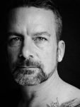 close-up black and white portrait of a bearded man in his 40th.